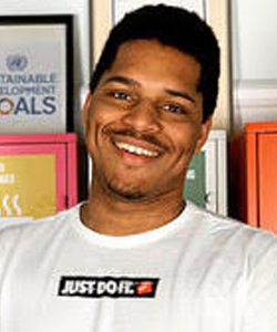 Photo of Treno Morton, smiling handsome African Nova Scotia man with short hair and a mustache wearing a Nike "Just Do It" tshirt.